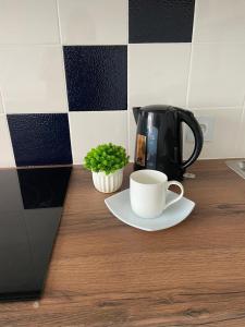 Апартаменты ЖК Сезим кала Бакыт Туран 55/12 في Taldykolʼ: وعاء القهوة وكوب من القهوة على منضدة +5 صور