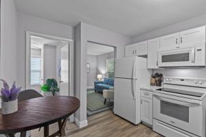 a kitchen with white appliances and a table and a dining room at Duplex Hideaway in Saint Charles MO in St. Charles +11 photos