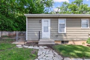 a small house with a white door in a yard at Duplex Hideaway in Saint Charles MO in St. Charles
