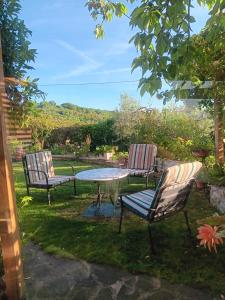 three chairs and a table in a yard at Poggio La Grognola in Cannara