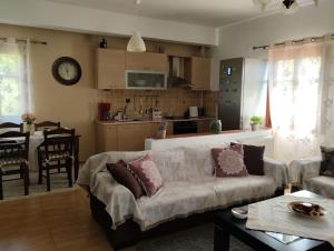 a living room with a couch and a kitchen at Christina's House - Neochori / Pelion in Neochori