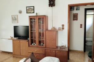 a living room with a tv and a wooden cabinet at Christina's House - Neochori / Pelion in Neochori