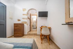 a bedroom with a bed and a desk and a chair at FEEL THE SERENITY in Galini