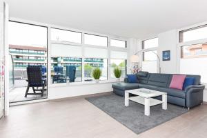 ein Wohnzimmer mit Sofa und Tisch in der Unterkunft Passagendeck Nordseegartenpark in Bensersiel