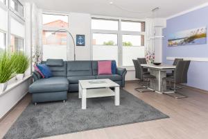 ein Wohnzimmer mit Sofa und Tisch in der Unterkunft Passagendeck Nordseegartenpark in Bensersiel