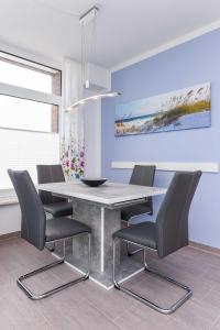 ein Esszimmer mit Tisch und Stühlen in der Unterkunft Passagendeck Nordseegartenpark in Bensersiel + 76 Fotos
