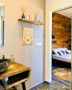 a bathroom with a sink and a bed in a room at S'accabbadora Guest House in Alghero
