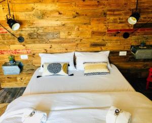 a bed in a room with a wooden wall at S'accabbadora Guest House in Alghero
