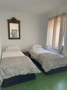 een slaapkamer met 2 bedden en een spiegel aan de muur bij Quinta do Eco in Vila de Rei