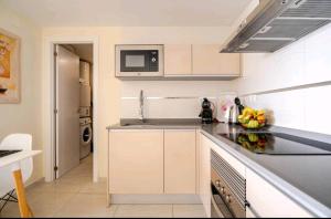 a kitchen with a counter top with a microwave at bellavista 4 frente a la playa Alicante in Alicante