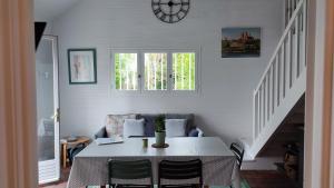 a dining room with a table and a clock on the wall at Le clos Saint Denis in Saint-Denis-en-Val
