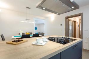 a kitchen with a counter top and a living room at Villa Velum in Mravince