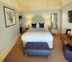 a bedroom with a large bed with a blue ottoman at The Royal Albion in Broadstairs