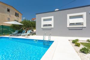 a swimming pool in front of a house at Villa Velum in Mravince