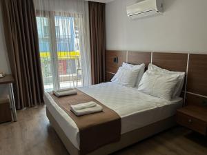 een slaapkamer met een bed met twee handdoeken erop bij Gulluk Life Hotel in Gulluk