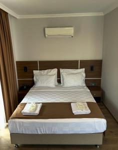 a bedroom with a bed with two towels on it at Gulluk Life Hotel in Gulluk