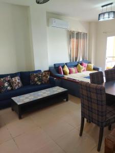 uma sala de estar com um sofá azul e uma mesa em Mousa Coast aquapark view chalet with garden em Ras Sedr