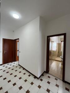 ein leeres Zimmer mit einer Tür und Fliesenboden in der Unterkunft Appartamento "Maruzzella" in Agropoli