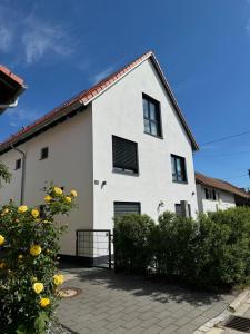 Casa blanca con ventanas negras y patio en Ferienziel Wibmer, en Landsberg am Lech