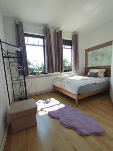 a bedroom with a bed and a chair and windows at SUNNY SIDE in Kiel
