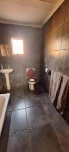 a bathroom with a toilet and a sink at Henning nest guest house in Centurion