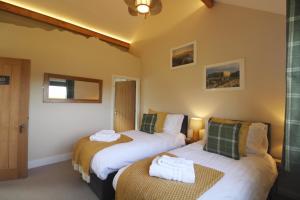 a bedroom with two beds with towels on them at Bridge House in Haltwhistle