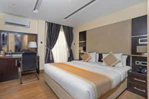 um quarto de hotel com uma cama e uma secretária em Watercress Hotels and Event em Ikeja