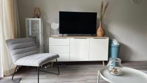 een woonkamer met een tv op een witte kast bij Appartement De Jutter, Resort Amelander Kaap in Hollum
