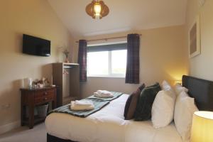 a bedroom with a white bed with a window at Bridge House in Haltwhistle