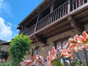 ein Gebäude mit einem Balkon und Blumen davor in der Unterkunft Apartamentos Calm & Nature en Liebana in Cabezón de Liébana