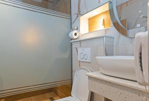 een badkamer met een wit toilet en een wastafel bij Watercress Hotels and Event in Ikeja