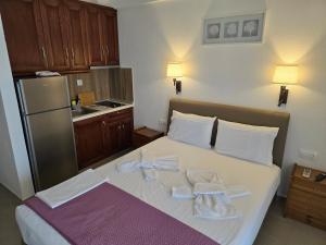 a bedroom with a bed with towels and a refrigerator at Itamos House Vourvourou in Vourvourou