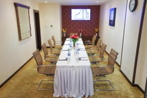 une salle de conférence avec une grande table et des chaises dans l'établissement Omega Hotel Dubai, à Dubaï