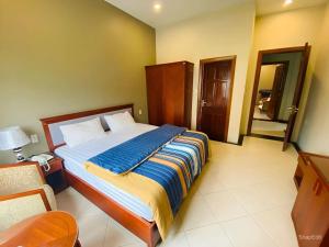 a bedroom with a large bed with a blue blanket at Nam Phong Hotel & Coffee in Cái Rồng