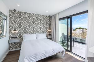 a bedroom with a bed and a balcony at The Orange House Boutique Hotel and Upstairs Rooftop Bar Center of La Cala de Mijas 100m from the Beach in La Cala de Mijas