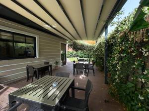 an outdoor patio with tables and chairs and a fence at Gulluk Life Hotel in Gulluk