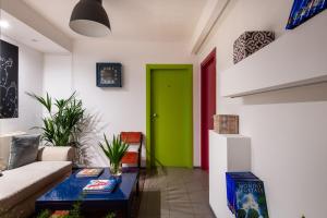 a living room with a green door and a couch at Pretoria Rooms in Palermo