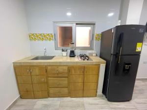 eine Küche mit Kühlschrank und Spüle in der Unterkunft Apartamento Villa Carolina 102 in Coveñas + 4 Fotos