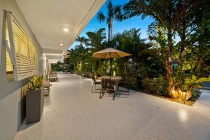 a patio with tables and chairs and an umbrella at Boutique Vacation Rental Complex At Beach in Cocoa Beach
