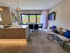 eine Küche und ein Wohnzimmer mit einem Tisch und Stühlen in der Unterkunft Luxury 5* Didsbury Family Home in Manchester
