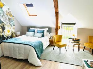 een slaapkamer met een bed en een tafel en stoelen bij Le Clos des Roses in Meusnes