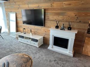 a living room with a fireplace and a flat screen tv at Luxusný byt pod Karpatami in Bratislava +3 photos