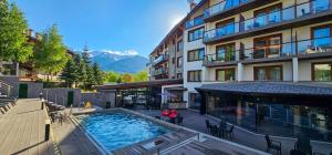 an outdoor swimming pool in front of a building at Studio with balcony, mountain view, 4* SPA Resort, Bansko in Bansko