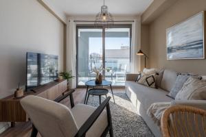 a living room with a couch and a tv at Stars 1-Bedroom Apartment in Larnaca in Larnaka