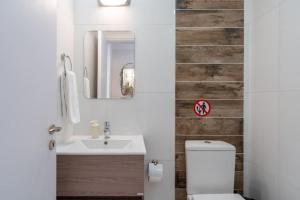 a bathroom with a sink and a toilet and a mirror at Stars 1-Bedroom Apartment in Larnaca in Larnaka +17 photos