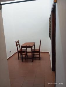 a table and two chairs in a room at Richie club des rois in Agonkamè
