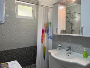 baño con lavabo y cortina de ducha en Sweet Garden, en Vogošća