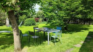 a table and chairs in the grass next to a tree at Le clos Saint Denis in Saint-Denis-en-Val
