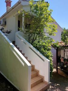 una scala di fronte a una casa con un albero di Studio Klara a Draga Bašćanska