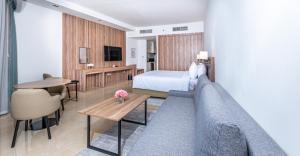 杜拜的住宿－Pyramisa Hotel Apartments，酒店客房配有床、沙发和桌子。